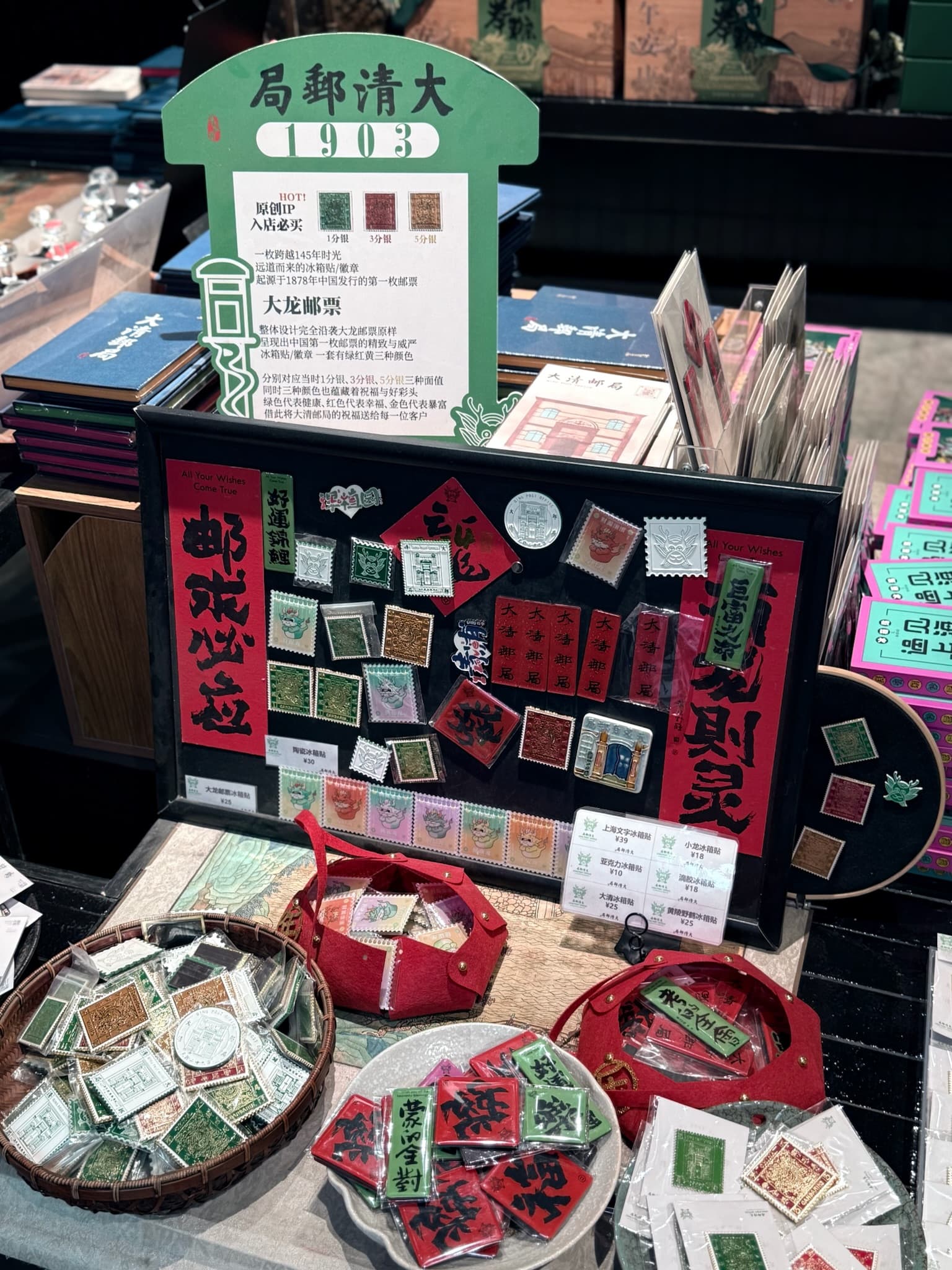 Framed vintage Chinese stamps and red calligraphy banners on display with baskets of souvenir items.